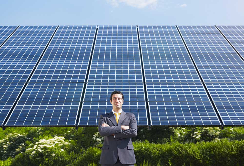 businessman in front of solar panels