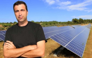 man in front of solar panels in field