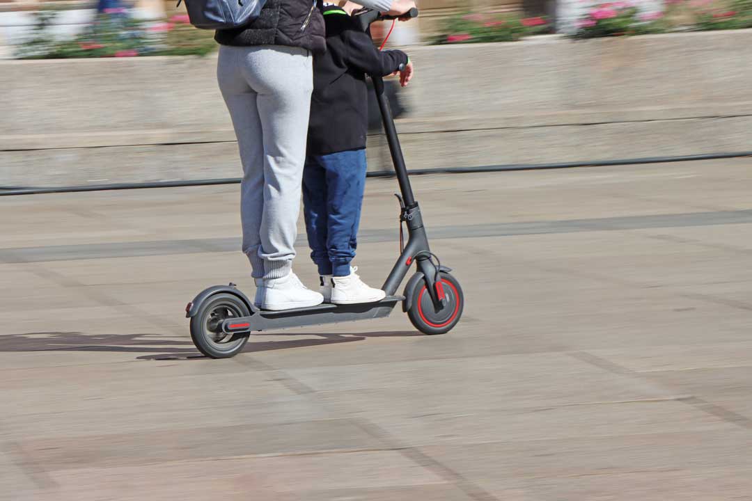 woman and son on electric scooter